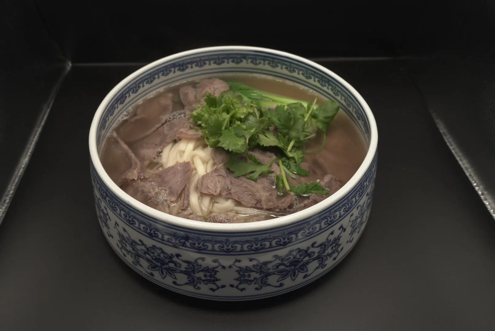 Beef noodle soup with cilantro and greens at Lao Hu Tong, a Asian Restaurant in Schaumburg