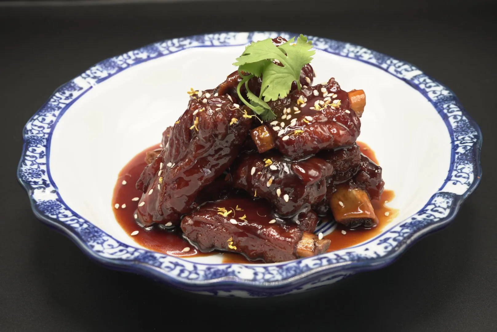 Sweet and sour pork ribs garnished with sesame seeds and cilantro at Lao Hu Tong, a Asian Restaurant in Schaumburg